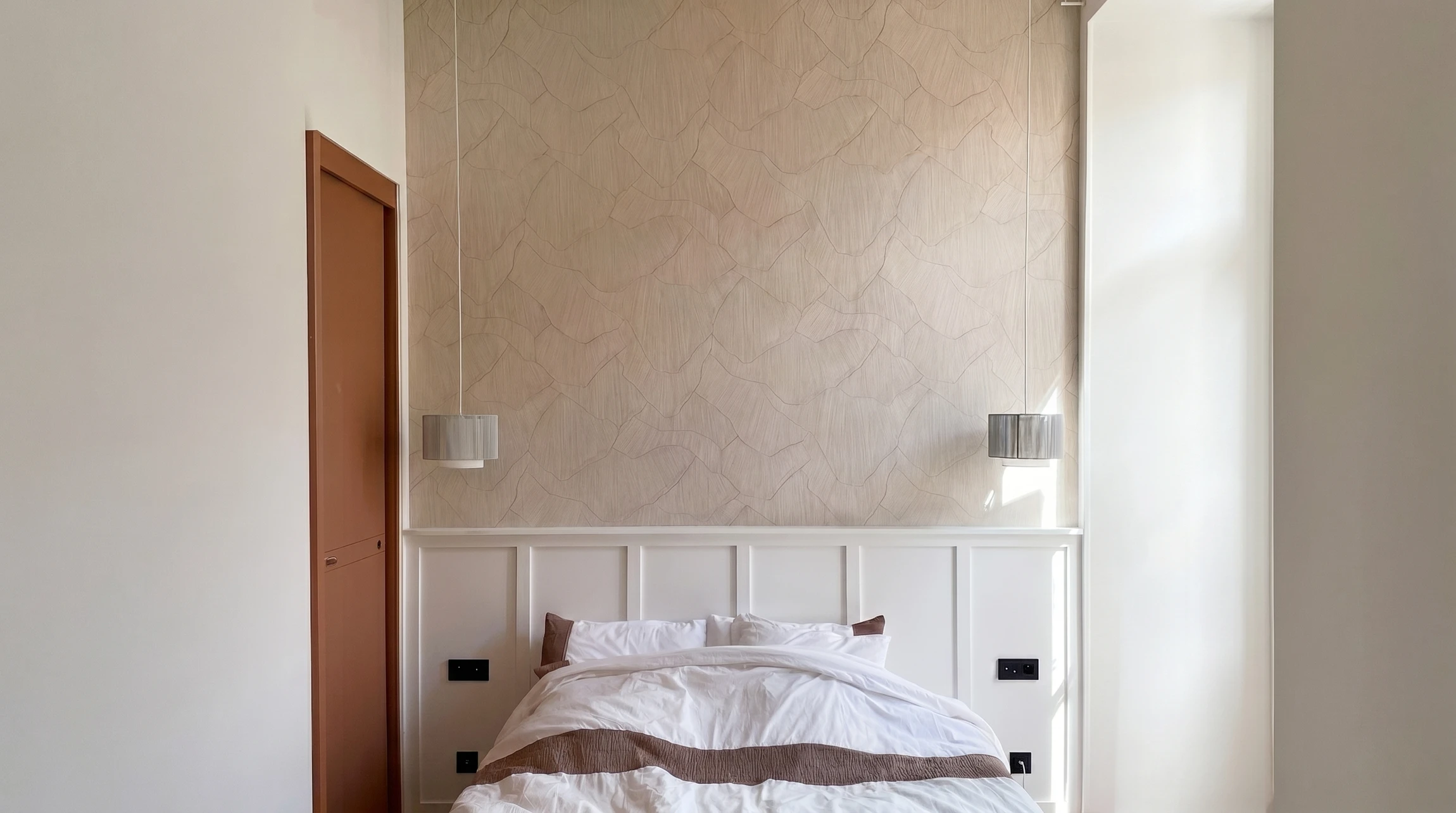 Un électricien installe une prise électrique murale blanche dans un intérieur moderne