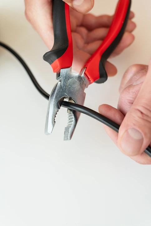 L'homme, un électricien travaillant dans un tableau à fusibles, utilise une tablette